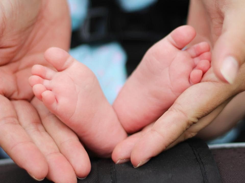 A newborn's feet held in two hands
