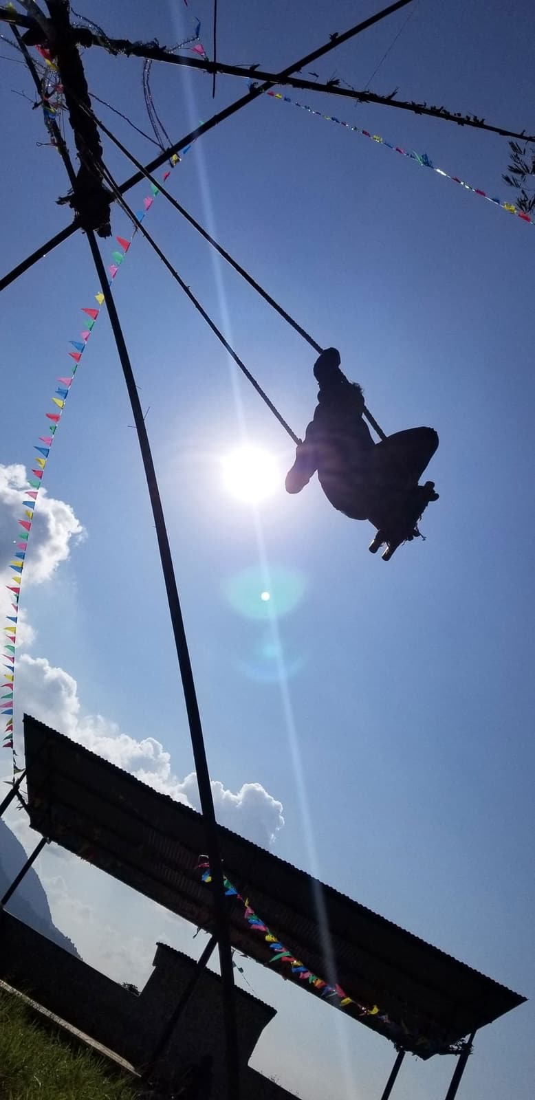 Someone flying high on a bamboo swing during Dashain