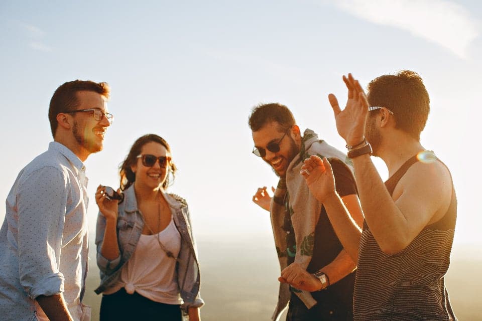 Friends laughing together at sunset