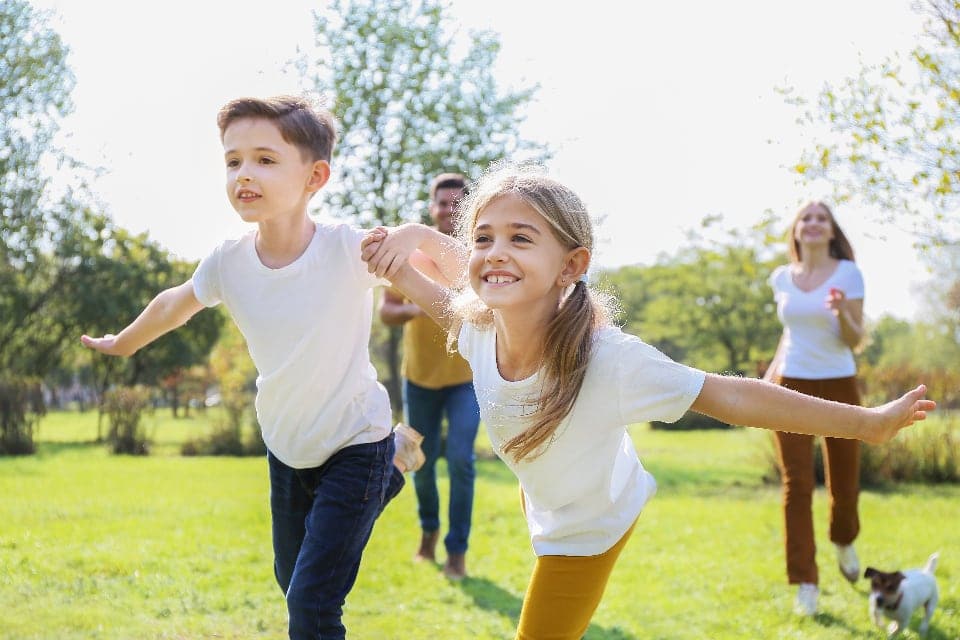 Two children running and laughing in a park