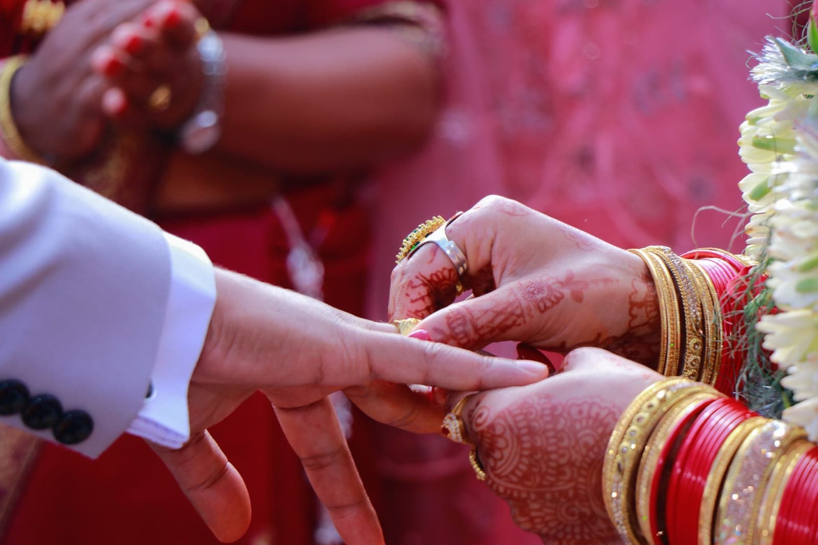 Hands with mehendi exchanging rings
